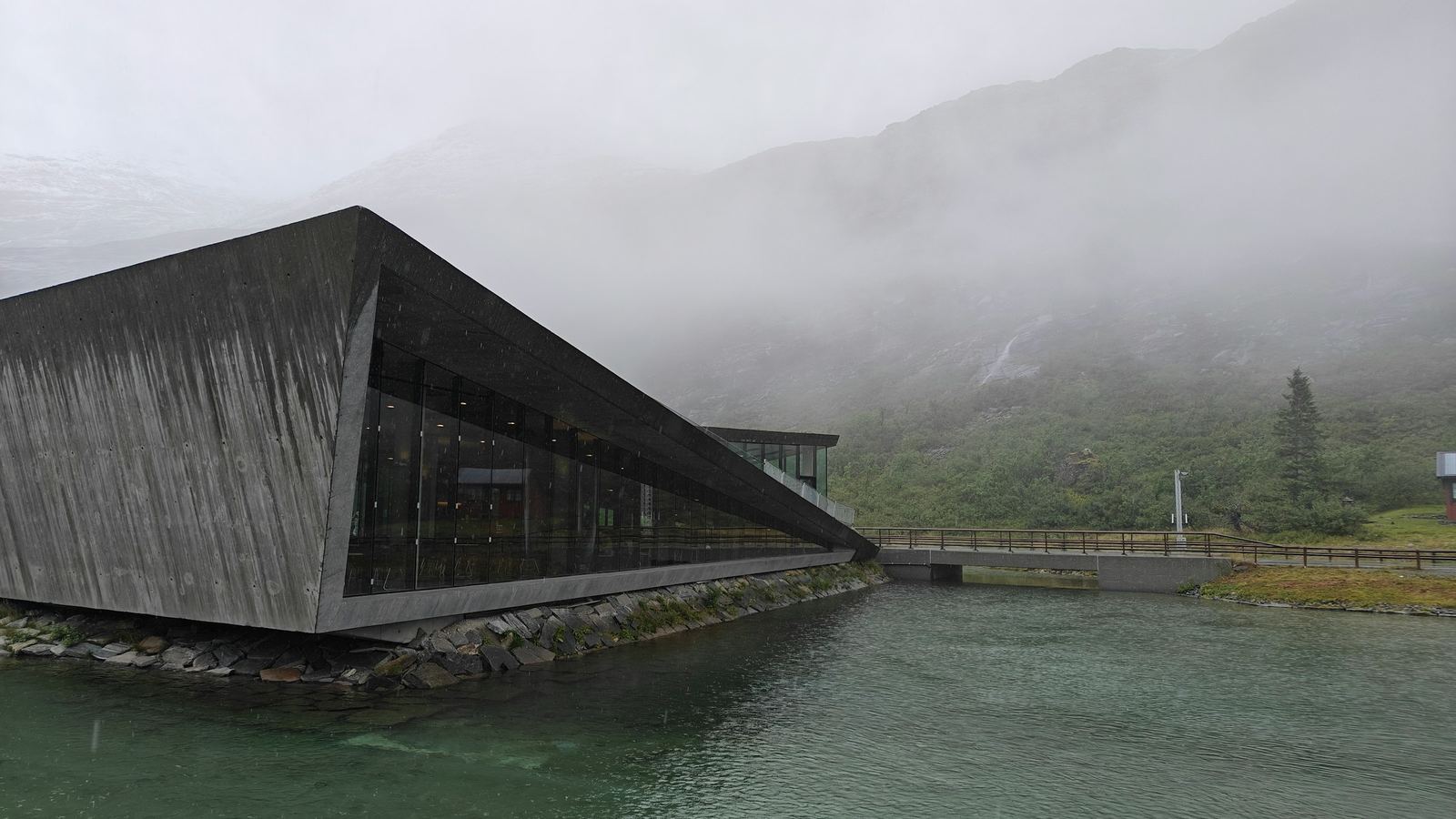 Concrete building beside water in mountains